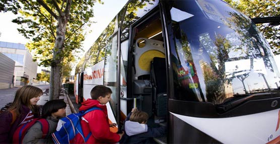 Varios niños accediendo al interior de un autobús escolar.