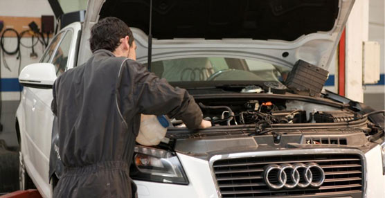 Mecánico trabajando en un taller de la marca Audi.