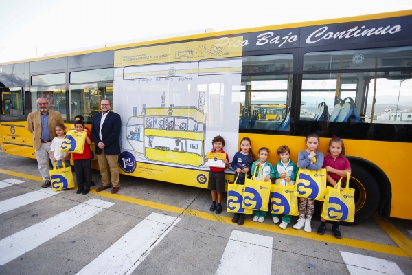 Los premiados en el concurso posan junto a un autobús de Guaguas Municipales.