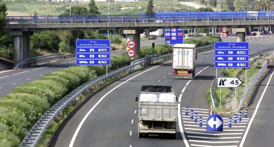 Dos camiones circulan por una autopista.