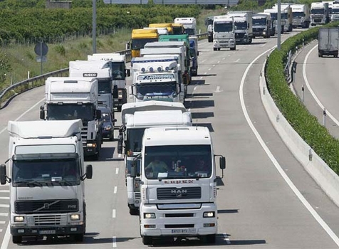 Varios camiones circulan por una carretera.