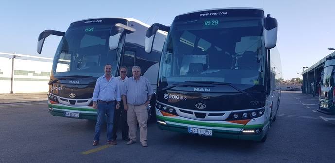 Representantes de Roig Bus, con dos de los autocares adquiridos.