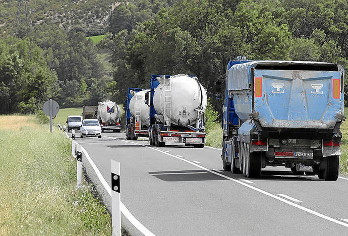 Varios camiones circulan por una carretera.