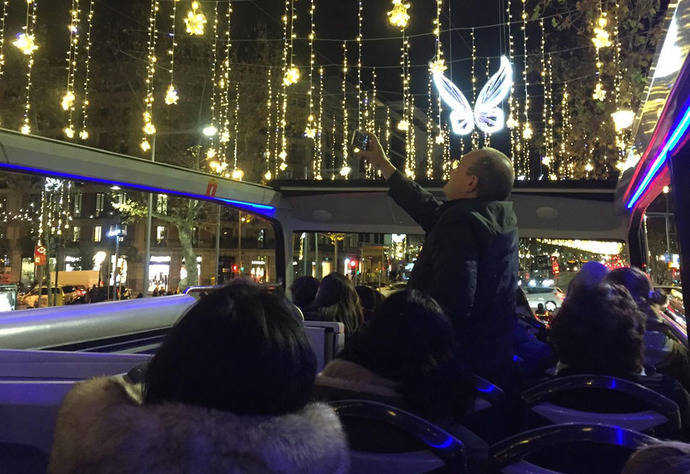 Varios pasajeros disfrutan de la vista de las luces navideñas de Barcelona.