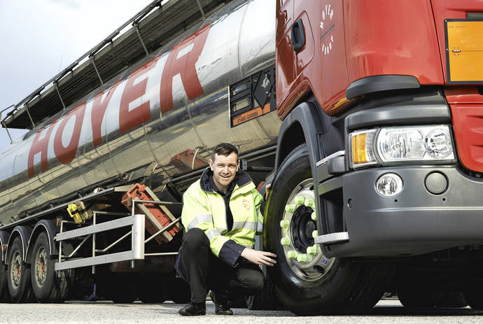 Un conductor posa con un neumático de su camión, de la nueva gama Michelin X Multi.