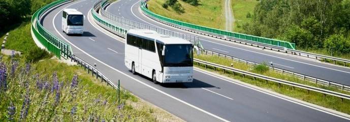 Dos autocares recorren una autopista.