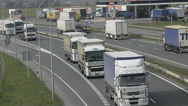 Varios camiones circulan por una carretera.