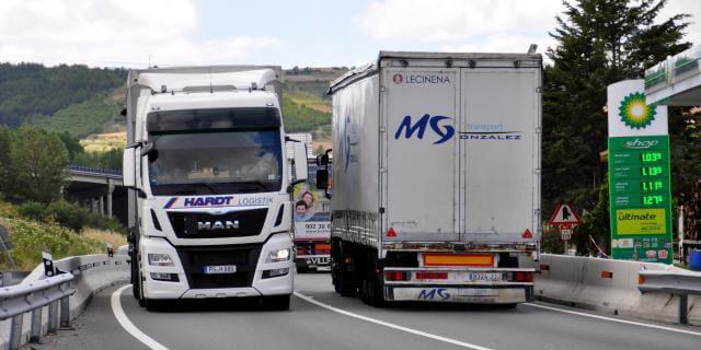 Dos camiones circulan por una carretera.