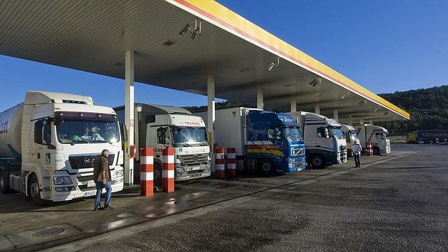 Varios camiones repostan en una estación de servicio.