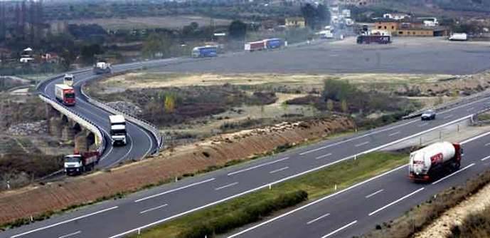 Varios camiones circulan por una carretera.