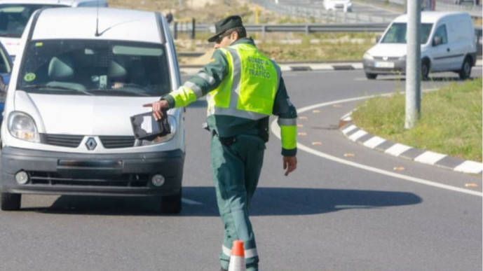 Un guardia civil manda estacionar a una furgoneta.