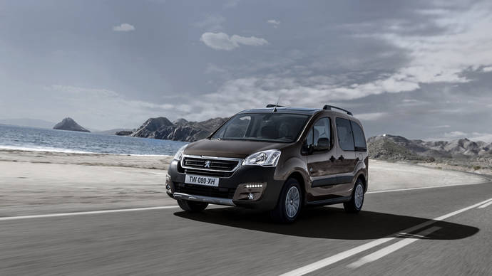 Fila de vehículos del modelo Peugeot Partner aparcados.