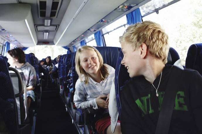 Varios niños acuden al colegio en un autobús escolar.